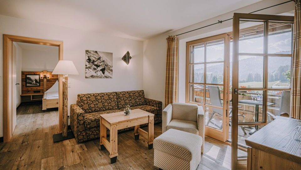Wohnraum mit Schlafcouch und Balkon in der Suite Himmelschrofen.
