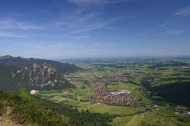 Blick von oben auf die Gemeinde Pfronten und das umliegende Tal.