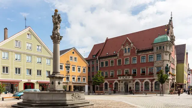Marienplatz in Mindelheim mit Mariensäule, farbigen Bürgerhäusern und historischem Rathaus. Ortsmotiv zur Ausflugsplanung.