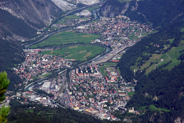 Blick von oben auf Landeck und Zams mit Inn, Bahntrasse und umliegenden Hängen
