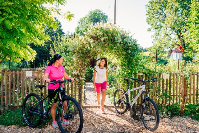 Radfahrerin an einem Garten im Württembergischen Allgäu