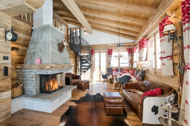 Wohnraum mit Kamin, Ledersofa und Wendeltreppe