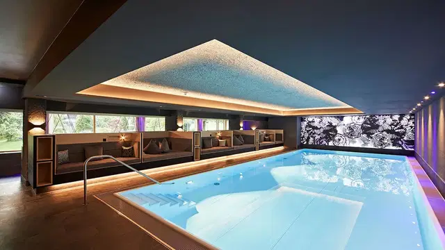 Innenpool-Lounge mit Sitzbankreihen, moderner Beleuchtung und ruhiger Atmosphäre.