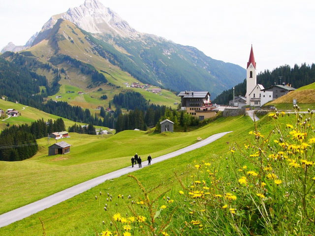 Warth mit Dorfkirche und sommerlichen Bergwiesen