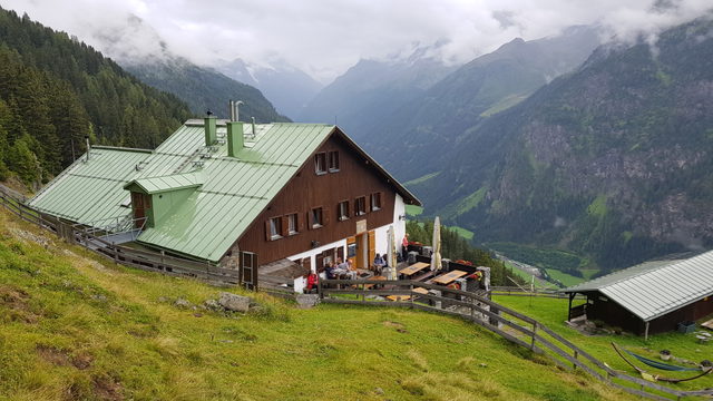 Ludwigsburger Hütte mit grünen Dächern und Terrasse über dem Pitztal
