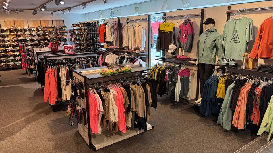 Sport- und Freizeitbekleidung mit Schuhregalen im Sportfachgeschäft
