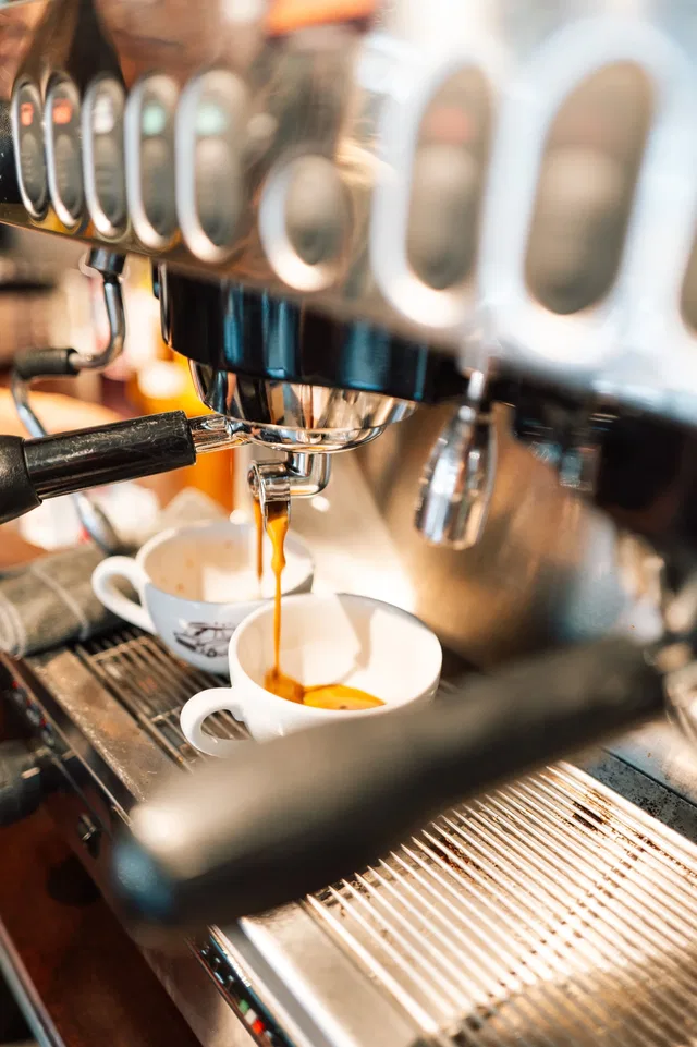 Espressoguss in eine weiße Kaffeetasse aus einer Espressomaschine