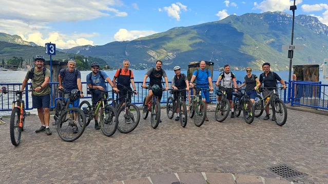 Zehn Radfahrende mit Mountainbikes am Gardaseeufer in Riva