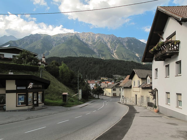 Straßenansicht in Tarrenz mit Häusern und Bergkette im Hintergrund