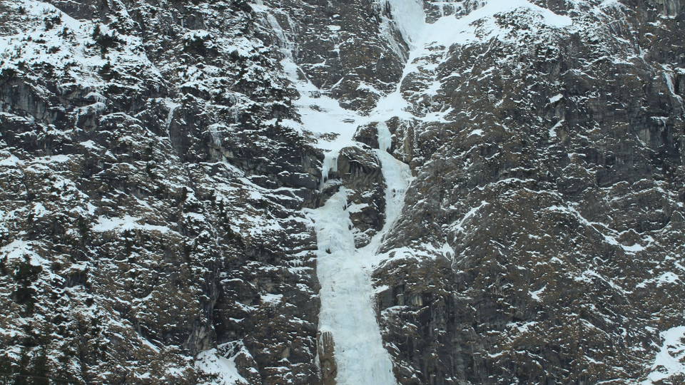 Teilweise gefrorener Fallbach an der Felswand bei Dalaas