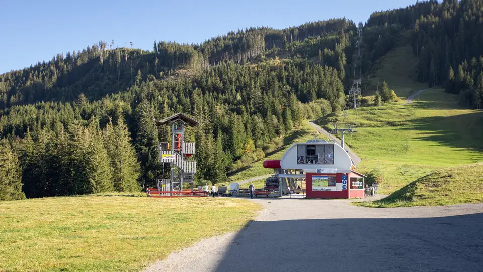 Skigelände mit Liftstation am Hang, Wald im Hintergrund