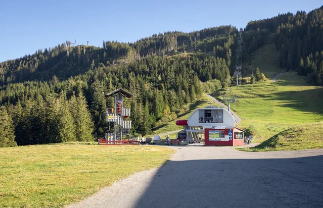 Skigelände mit Liftstation am Hang, Wald im Hintergrund