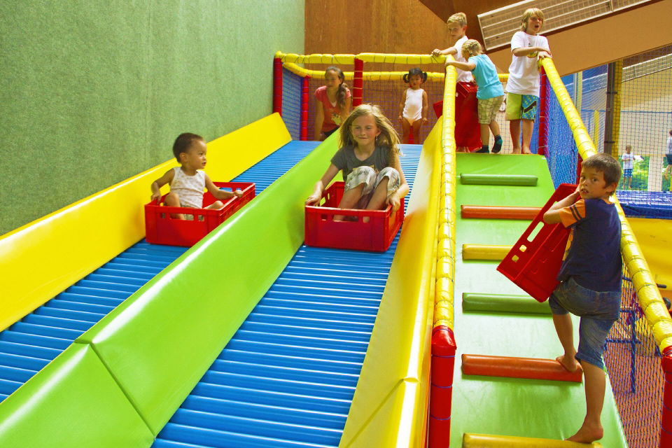 Kinder rutschen auf der Rollenrutsche