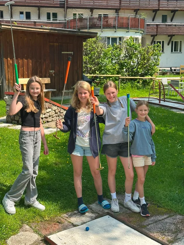 Kinder mit Minigolf-Schlägern im Außenbereich