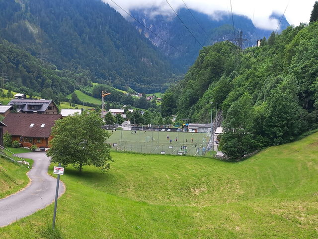 Blick auf Dalaas mit Sportplatz und umliegenden Berghängen