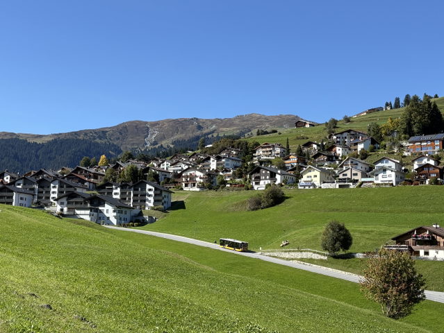 Blick auf Falera mit Wohnhäusern, Wiesen und Dorfkirche
