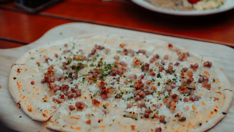Flammkuchen mit Speck und Schnittlauch in der Gaststube Bienenkorb