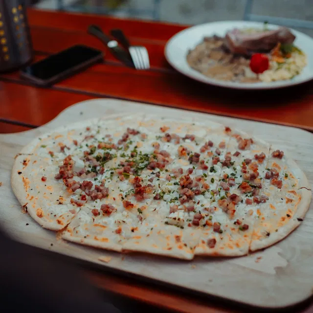 Flammkuchen mit Speck und Schnittlauch in der Gaststube Bienenkorb