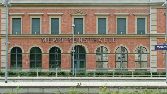 Backsteinfassade der MEWO Kunsthalle mit großen Rundbogenfenstern, vom Memminger Bahnhof aus gesehen. Ortsmotiv zur Ausflugsplanung.