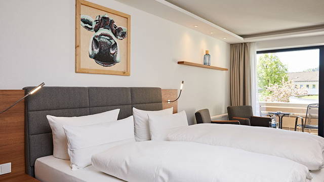 Doppelbett und Fensterfront im Zimmer Nebelhorn