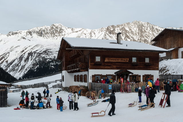 Gleirschalm im verschneiten Gleirschtal mit Gästen auf der Terrasse
