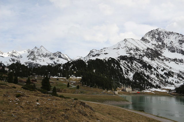 Längentaler Speicher bei Kühtai mit Wald und verschneiten Berghängen