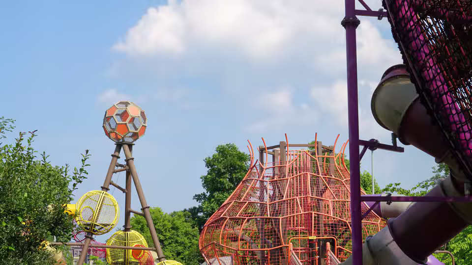 Symbolbild: Spielplatz mit Klettertürmen und Rutschen im Freien. Keine Originalaufnahme des Anbieters.