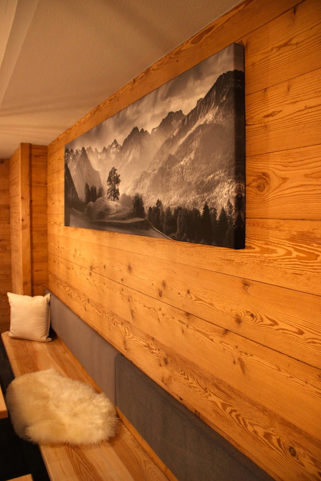 Sitzbereich mit Holzwand und Bergbild im Café Kaffeekränzle