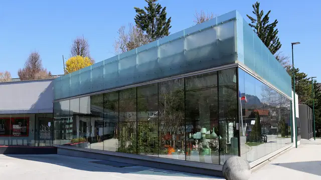 Gläserne Fassade des RIEDEL Besucher- und Verkaufsbereichs in Kufstein. Ortsmotiv.