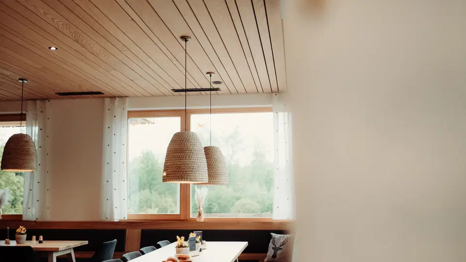 Heller Gastraum der Gaststube Bienenkorb mit Holzdecke und gedeckten Tischen