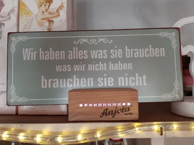 Holzschild mit dem Spruch: Wir haben alles was sie brauchen was wir nicht haben brauchen sie nicht