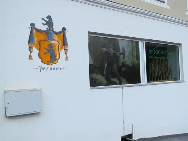 Weiße Fassade mit Wappen links und Werbefenster rechts (3D-BOGENSTADT)