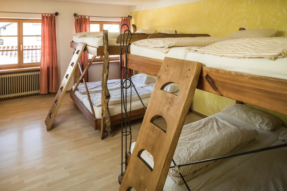 Zimmer Kojen mit zwei breiten Holzstockbetten und Leitern