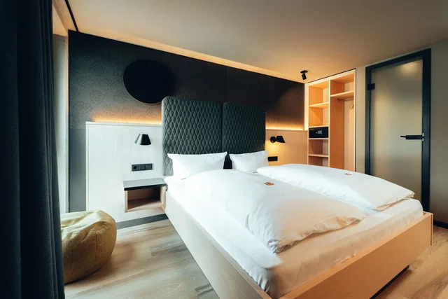 Modernes Hotelzimmer mit zwei Betten und gepolsterten Kopfteilen