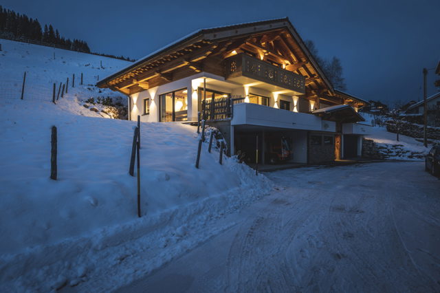 Beleuchtetes Chalet Steinbock im Schnee am Hang