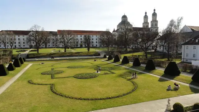 Blick über den Hofgarten in Kempten mit geometrischen Beeten, Wegen und der Residenz mit St. Lorenz im Hintergrund. Ortsmotiv.