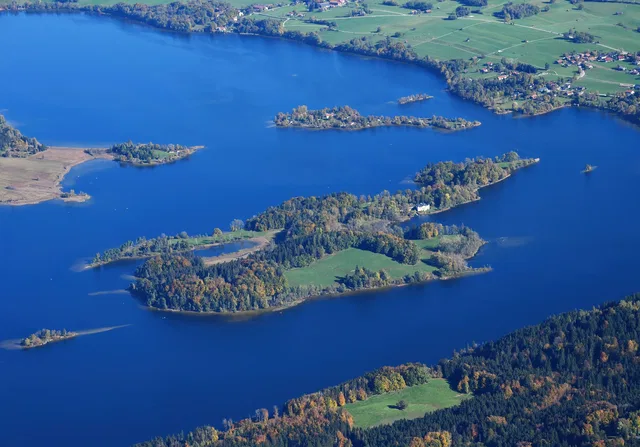 Luftaufnahme eines großen Sees mit Inseln und grünem Uferland