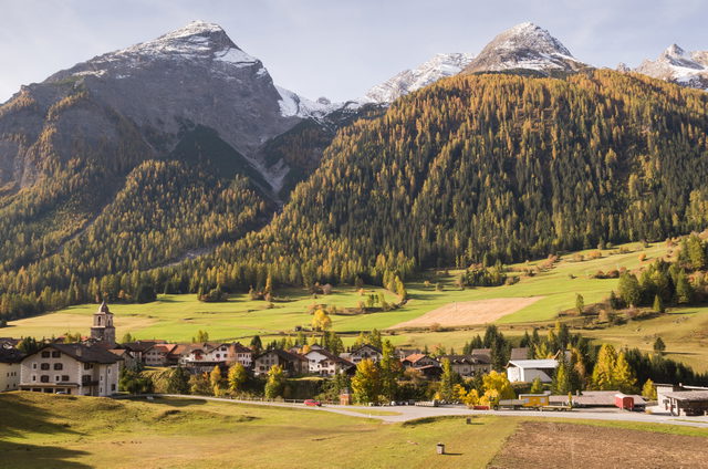 Bergün mit historischen Häusern und Kirche vor herbstlichen Bergen