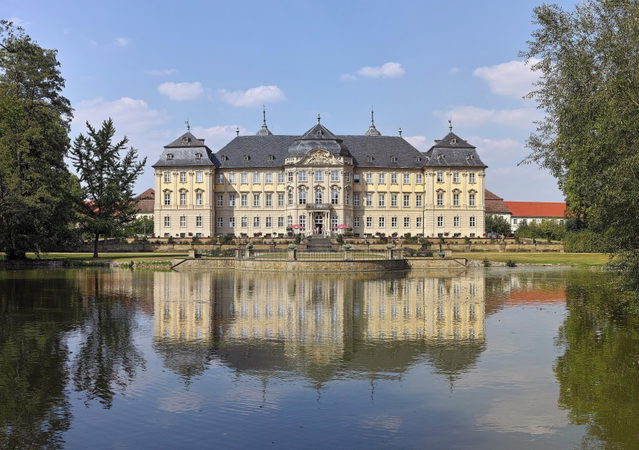 Schloss Werneck mit Spiegelung im Wasser des Schlossparks