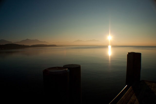 Sonne über dem Chiemsee und der Alpenkette, gesehen vom Dampfersteg in Chieming