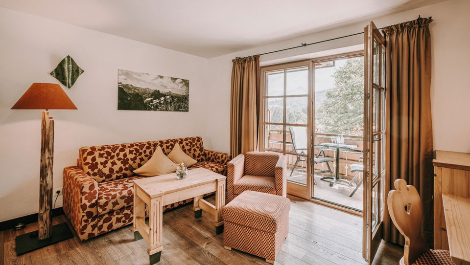 Wohnbereich mit Sofa und Balkontür in der Suite Höfats.