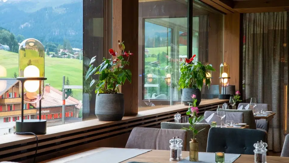 Gedeckte Tische an großen Fenstern mit Blick ins Kleinwalsertal