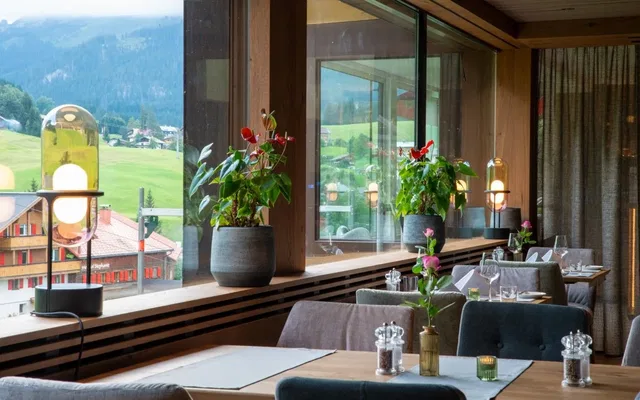 Gedeckte Tische an großen Fenstern mit Blick ins Kleinwalsertal