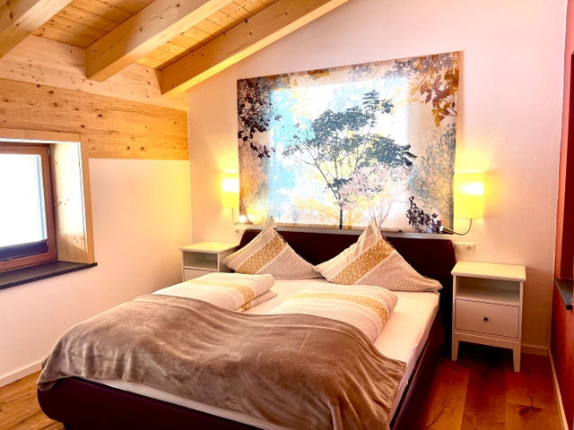 Schlafzimmer der Ferienwohnung Solara mit Doppelbett und Waldmotiv