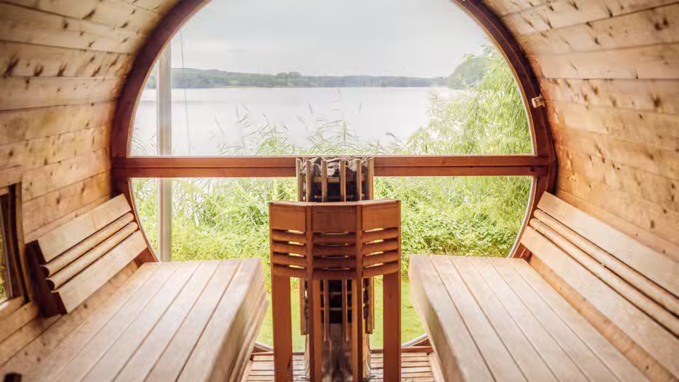 Symbolbild: Holzsauna mit Blick ins Grüne. Keine Originalaufnahme des Anbieters.