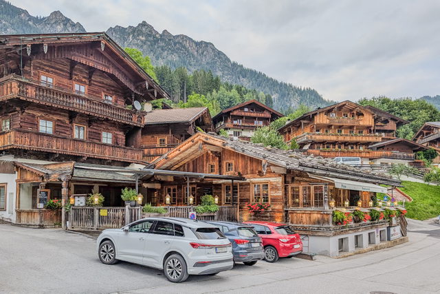 Holzhäuser in Alpbach vor bewaldeter Bergkulisse
