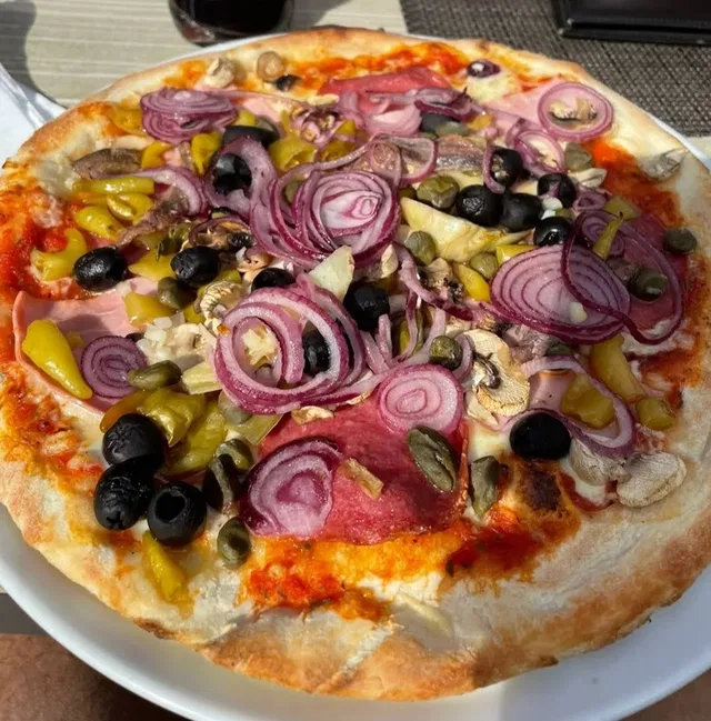 Pizza mit Salami, Schinken, Zwiebeln und Oliven