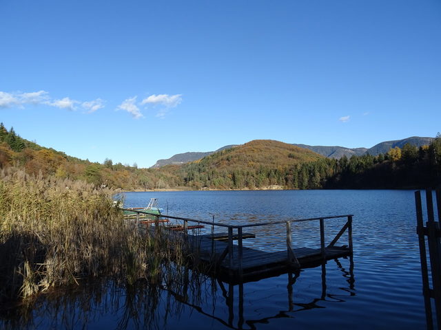Großer Montiggler See mit bewaldeten Ufern und Holzsteg
