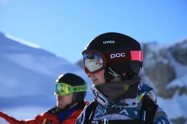 Ski- bzw. Snowboarder mit Helm und schwenkbarer Schutzbrille im Schnee