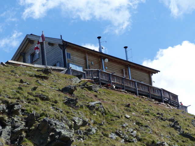 Brunnenkogelhaus mit Holzfassade auf einem Bergrücken über Sölden
